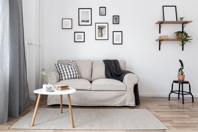 Canapé clair et une table basse scandinave blanche sur trois pieds en bois clair